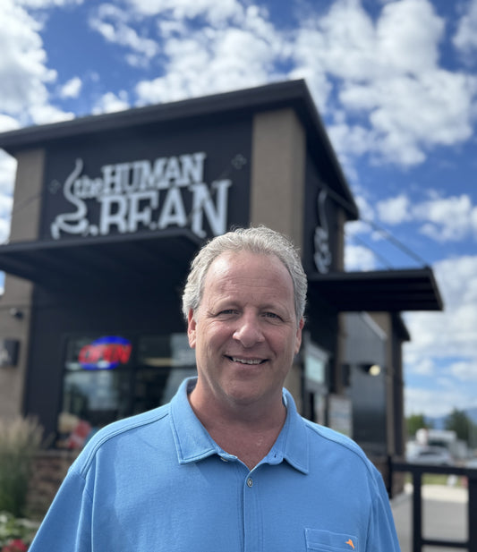 Scott Anderson standing in front of The Human Bean coffee stand.